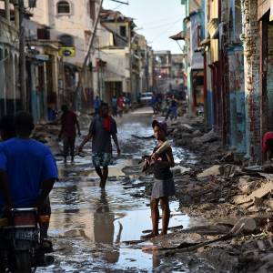 A girl walks on a street damaged in Hurricane Matthew, in Jeremie, in western Haiti, on October 7, 2016. The full scale of the devastation in hurricane-hit rural Haiti became clear as the death toll surged over 400, three days after Hurricane Matthew leveled huge swaths of the country's south. (Photo by Hector Retamal/AFP/Getty Images)