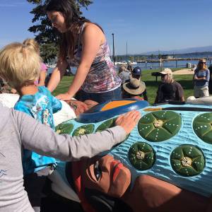 Residents of Sandpoint, Idaho get see and touch the 22-foot totem pole during a gathering on Sunday. (Photo by Susan Drumheller)