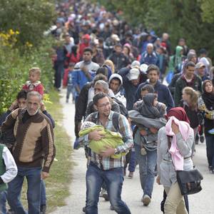 Refugees and migrants walk through the Hungarian town of Hegyeshalom on their way to the border where they will cross into Austria. Hundreds of thousands of refugees and migrants flowed through Hungary in 2015, on their way from Syria, Iraq and other countries to western Europe. The ACT Alliance has provided critical support for refugee and migrant families here and in other places along their journey. (Photo by Paul Jeffrey)