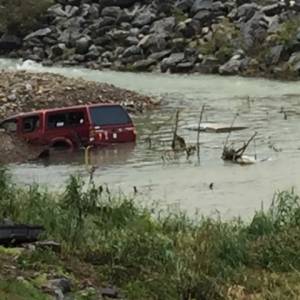 A pickup truck is left partially submerged in the aftermath of flooding in West Virginia. (Photo by Phillip Darby)