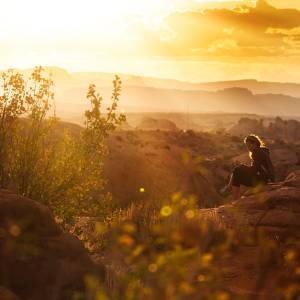 Woman sitting quietly on a rock enjoying nature