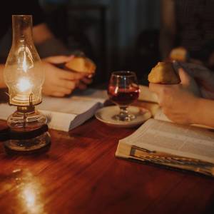 People at a table with Bibles, bread and wine