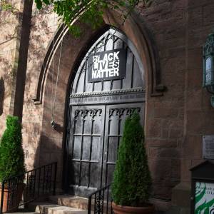 A Black Lives Matter sign over a church door entrance.