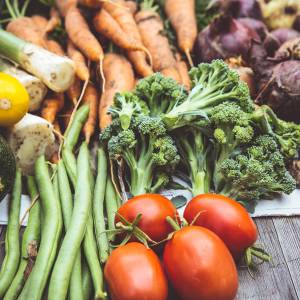 an assortment of fresh vegetables on a wooden table