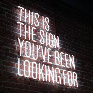 Neon sign on brick wall that reads ‘This is the sign you’ve been looking for’