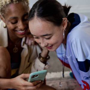 couple laughing as they look at social media post on a mobile phone