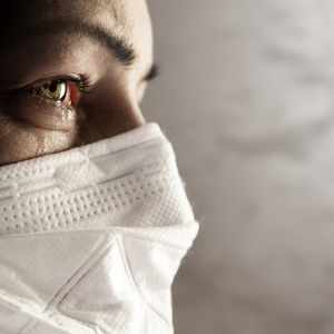 Teary-eyed woman wearing face mask