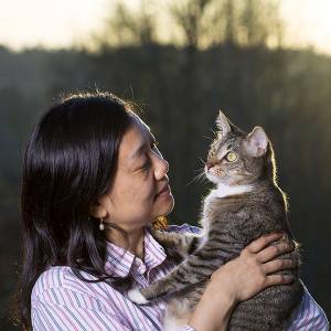 Woman holding cat and smiling