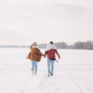 Couple walking hand-in-hand in the snow.