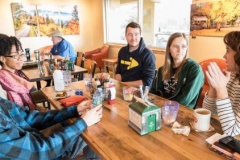 YAVs (from left) Jeremy Glidden, Briana Joseph, Andy Thomas and Sammie Smith at their weekly meeting with Asheville YAV site coordinator Selena Hilemon. (Photo by Gregg Brekke)