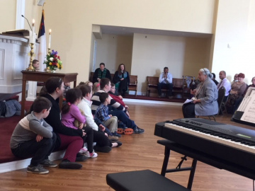 Both adults and children listen intently to the children’s sermon.