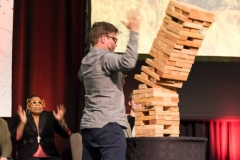 Denise Anderson, co-moderator of the 222nd General Assembly of the PC(USA), reacts as Carl Horton lifts his hands when the Jenga tower on stage at the APCE ‘Holy Humor’ worship service collapses. (Photo by Gregg Brekke)