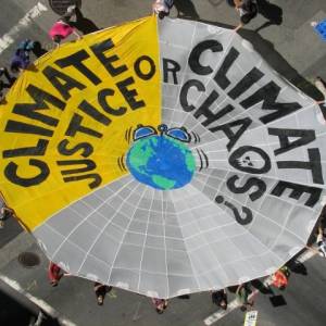 globe and web with climate justice or climate chaos printed on it