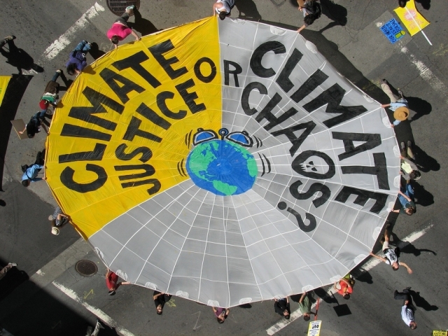 globe and web with climate justice or climate chaos printed on it