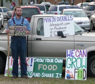 Photo of Nathan in parking lot with pitchfork "Will garden for food"