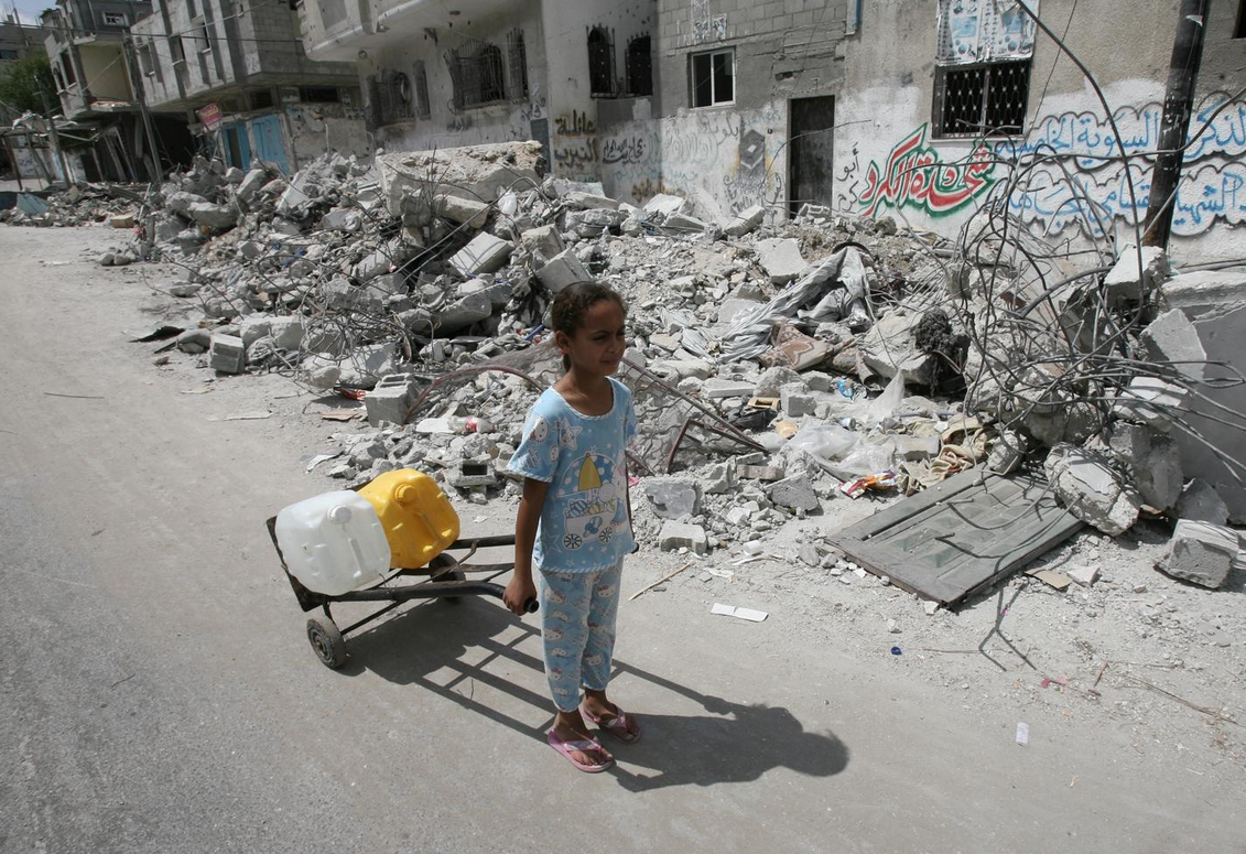 Palestinian girl dragging water containers